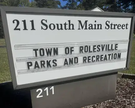 Outdoor sign that lists "211 South Main Street - Town of Rolesville Parks & Recreation"