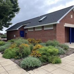 Green garden with brick building for bathrooms and concessions.