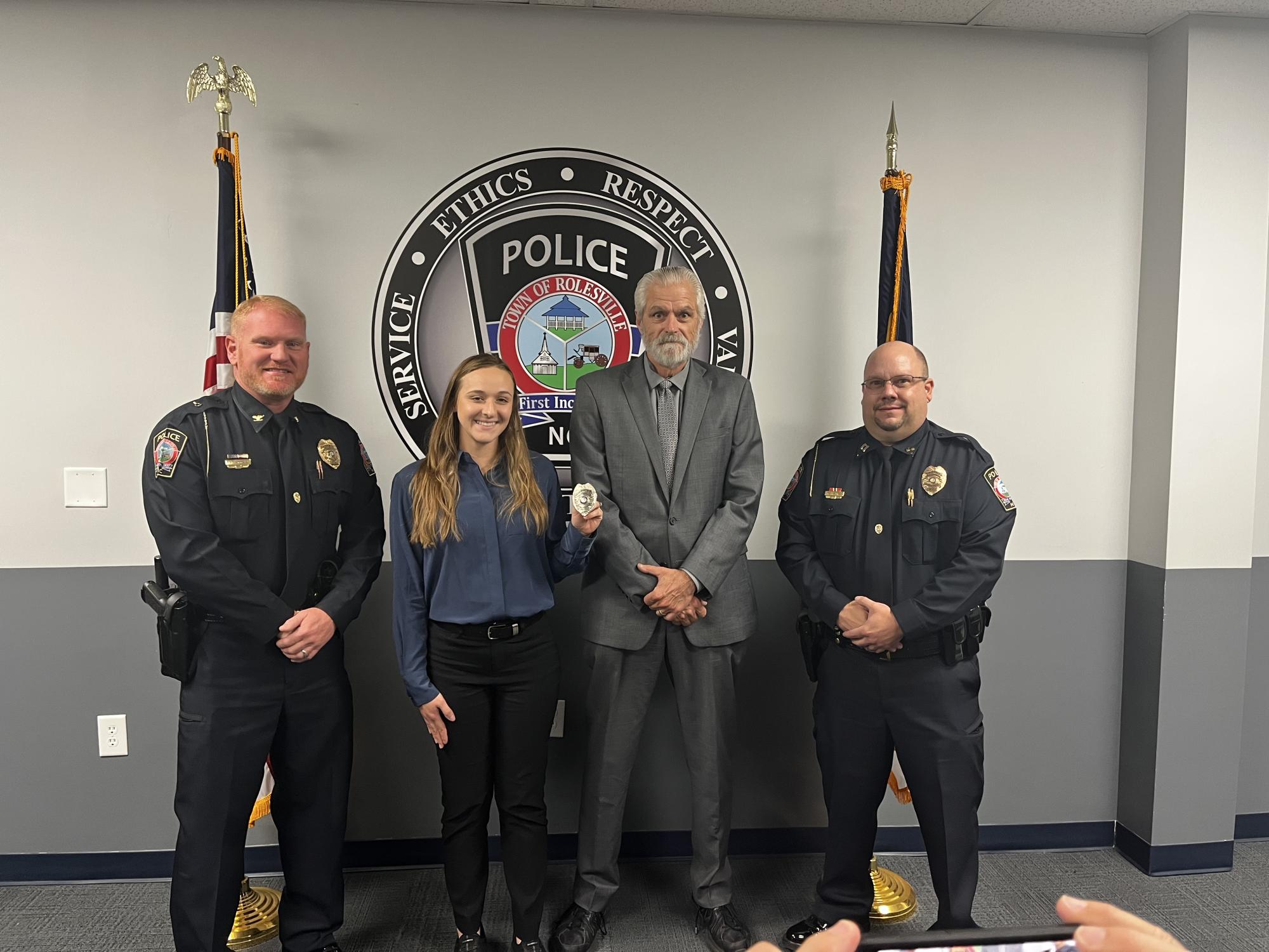 Mayor standing with police officers in black uniforms. 