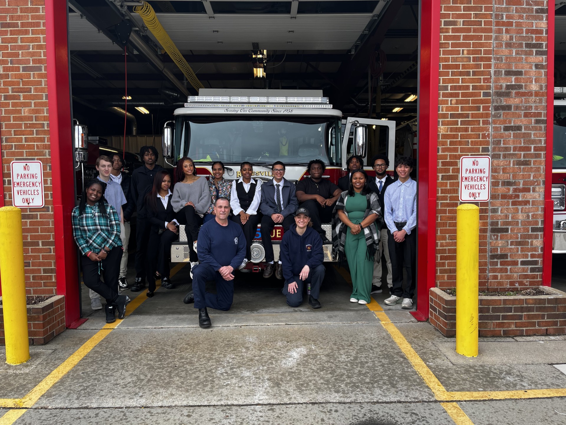 Children with Youth Leadership Rolesville pose in front of a fire truck.