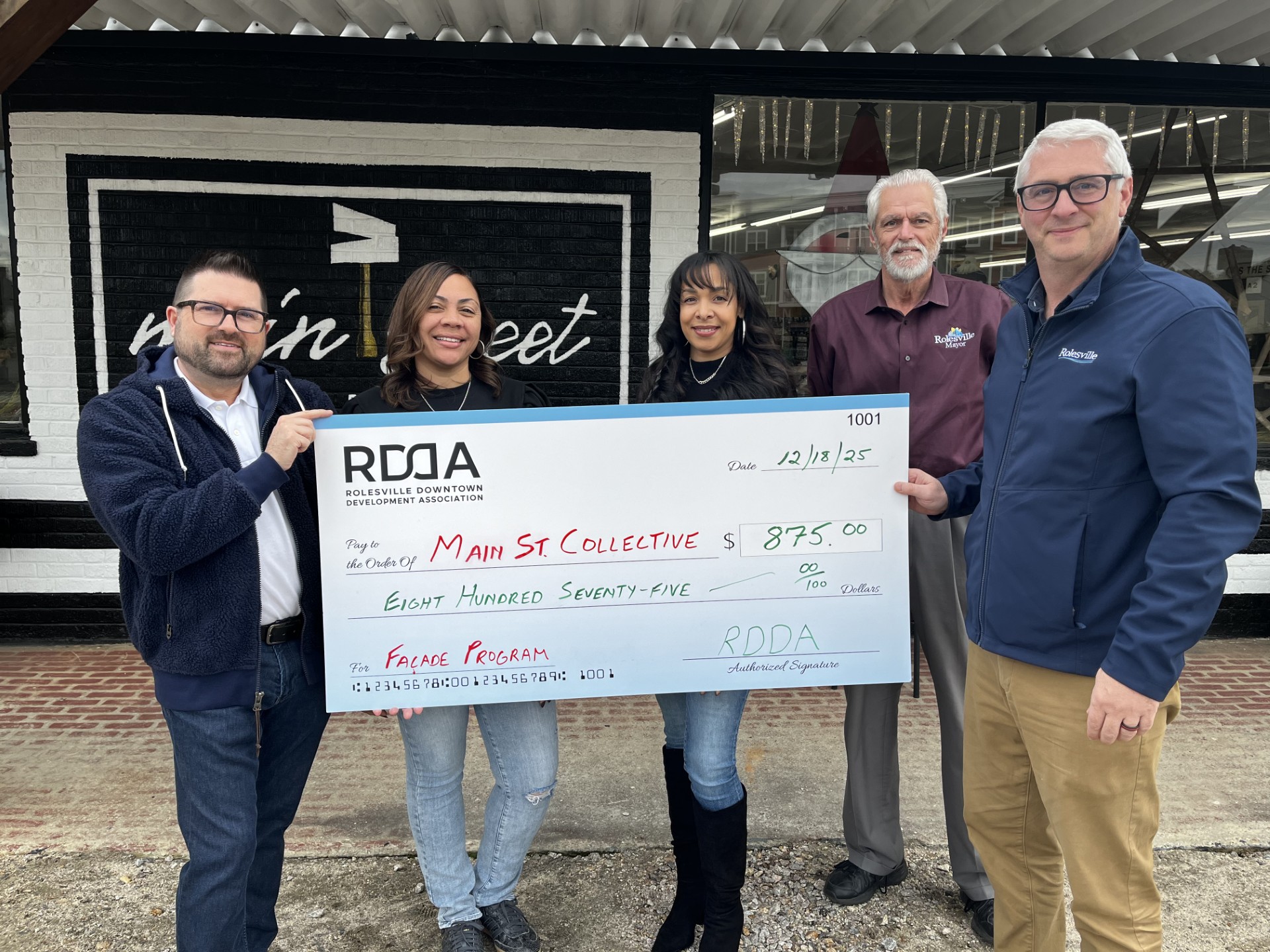 Four people standing in front of a store